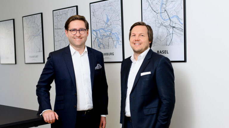 Die Geschäftsführer von Rothbaum im Büro München. Links steht Dr. Kai Philipp Bauer und rechts ist Philipp Carl.