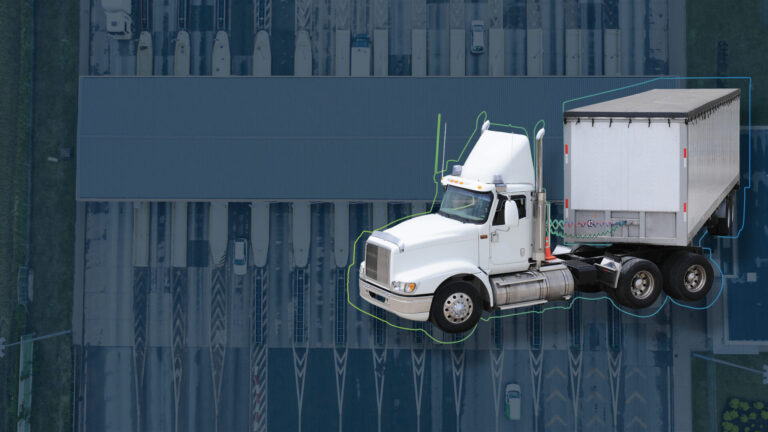 Headerbild zur Seite "Transport Management Systeme" (TMS), zeigt einen großen Warentransporter im Vordergrund und ein Logistikzentrum bzw. Verteilerzentrum im Hintergrund.